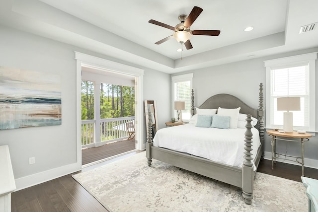 bedroom with baseboards, access to outside, wood finished floors, and visible vents
