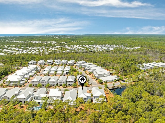 bird's eye view featuring a water view, a residential view, and a wooded view
