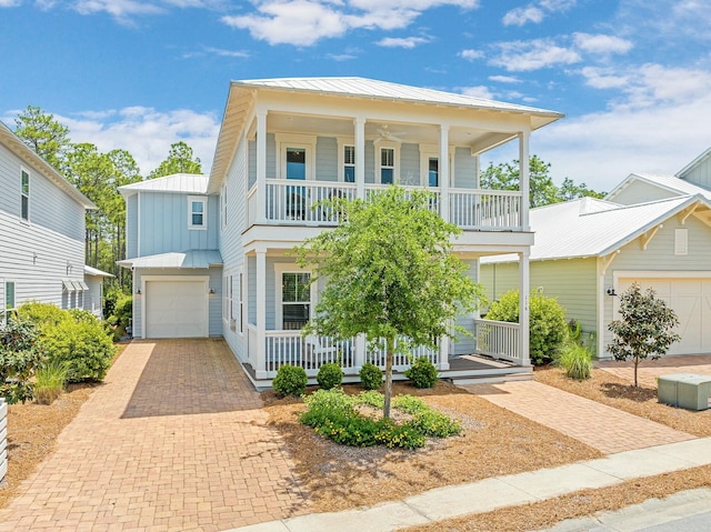 view of front of house featuring a balcony, covered porch, decorative driveway, a standing seam roof, and metal roof