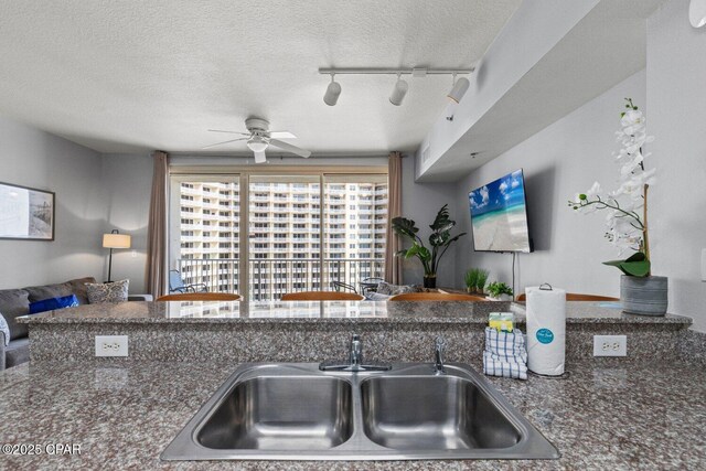 9900 S Thomas Dr Unit 1408, Panama City Beach, FL 32408 - kitchen with a sink, a textured ceiling, dark countertops, ceiling fan, and track lighting