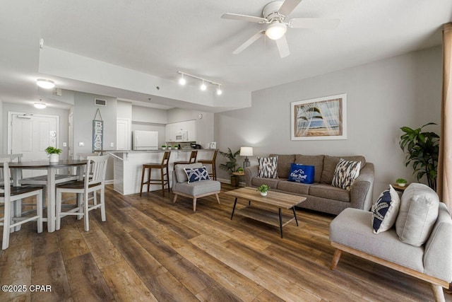 living area with rail lighting, visible vents, wood finished floors, and ceiling fan