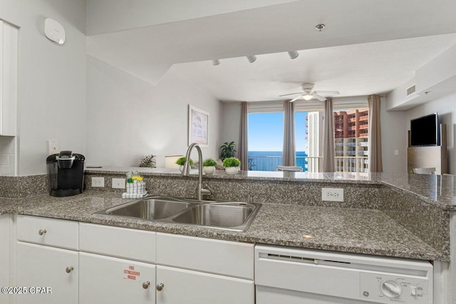 kitchen with dishwashing machine, a ceiling fan, a sink, white cabinetry, and visible vents