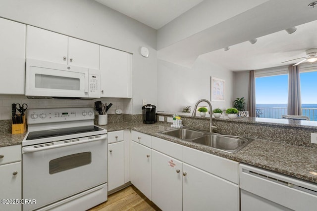 kitchen featuring white cabinets, light wood-style floors, a sink, and white appliances