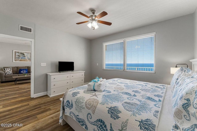 bedroom with baseboards, dark wood finished floors, visible vents, and a ceiling fan