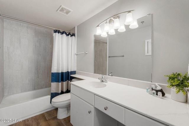 full bathroom with toilet, wood finished floors, shower / tub combo, visible vents, and vanity