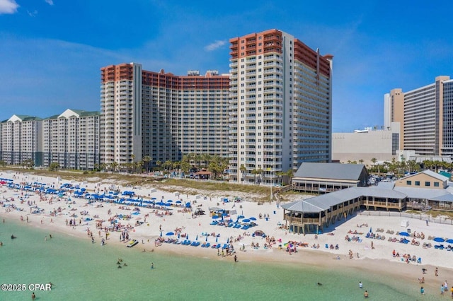 view of building exterior with a beach view, a water view, and a view of city