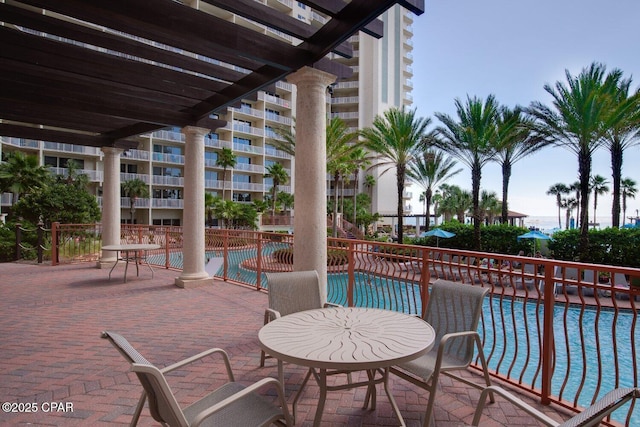 view of patio / terrace featuring fence and a community pool