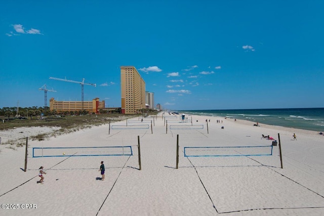 surrounding community with a water view and a beach view