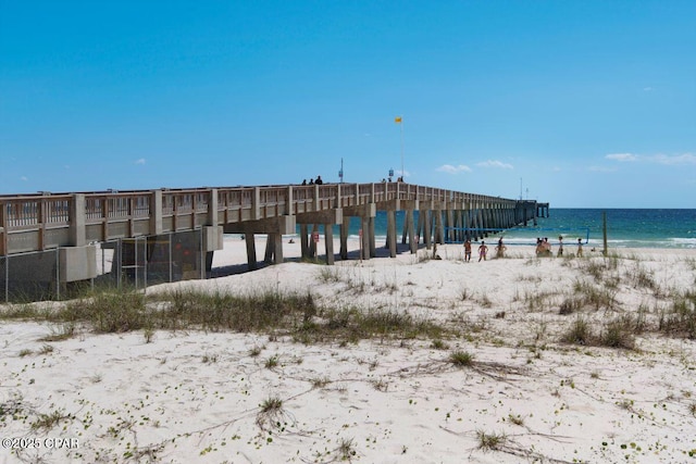 view of dock featuring a water view and a view of the beach