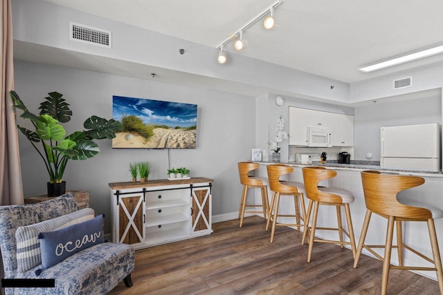 9900 S Thomas Dr Unit 1410, Panama City Beach, FL 32408 - kitchen with white cabinets, white appliances, wood finished floors, and visible vents