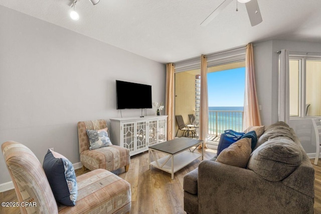 9900 S Thomas Dr Unit 1410, Panama City Beach, FL 32408 - living area with baseboards, a ceiling fan, and wood finished floors