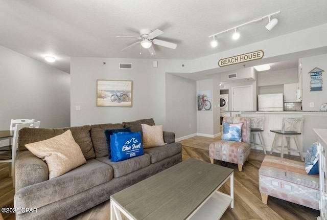 9900 S Thomas Dr Unit 1410, Panama City Beach, FL 32408 - living area featuring a ceiling fan, visible vents, stacked washer / dryer, and wood finished floors