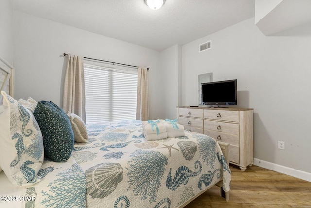 9900 S Thomas Dr Unit 1410, Panama City Beach, FL 32408 - bedroom with visible vents, baseboards, and wood finished floors