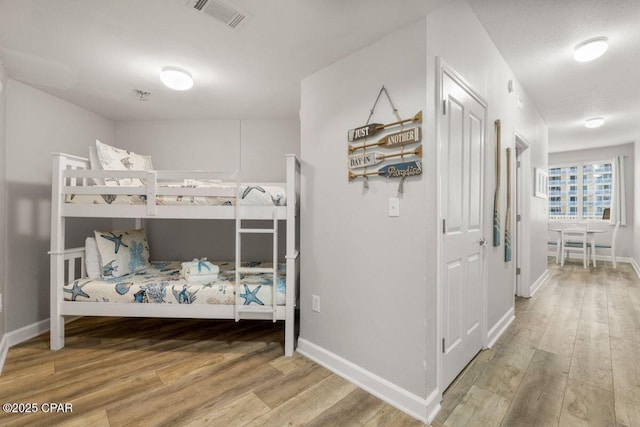 9900 S Thomas Dr Unit 1410, Panama City Beach, FL 32408 - bedroom featuring baseboards, visible vents, and wood finished floors