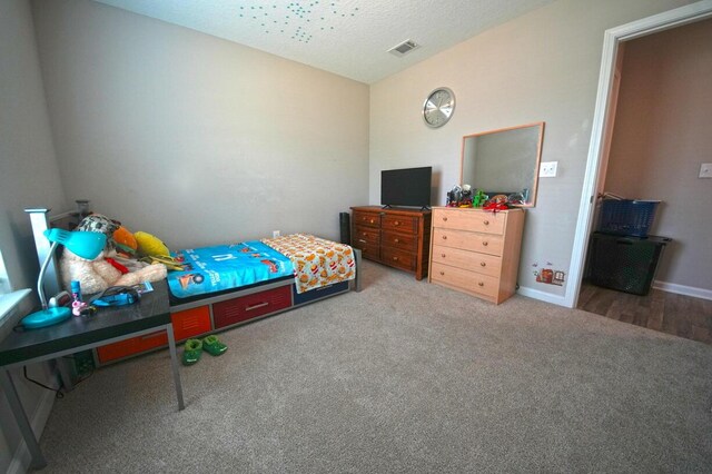 5594 Riviera Dr, Milton, FL 32583 - carpeted bedroom with visible vents, a textured ceiling, and baseboards