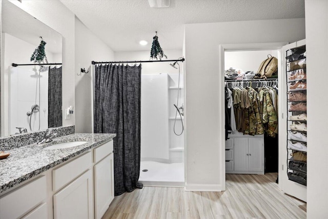 810 Otto Loop, Crestview, FL 32539 - full bath with a stall shower, a textured ceiling, vanity, wood finished floors, and a spacious closet
