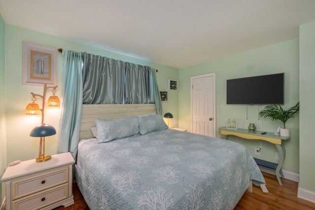 bedroom with wood finished floors and baseboards