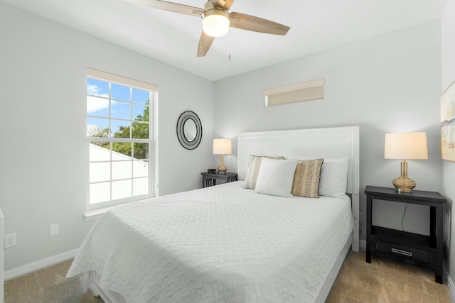bedroom with a ceiling fan, baseboards, and carpet