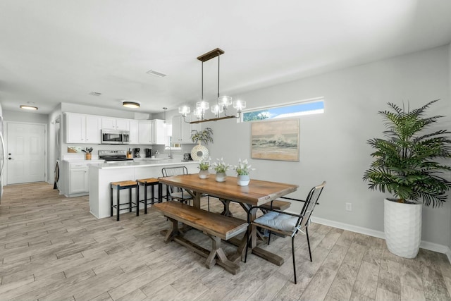 dining room featuring baseboards, an inviting chandelier, visible vents, and light wood-type flooring