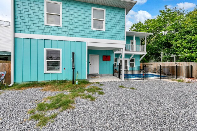 26 Daytona St, Miramar Beach, FL 32550 - view of front of home featuring fence, board and batten siding, a fenced in pool, a balcony, and a patio