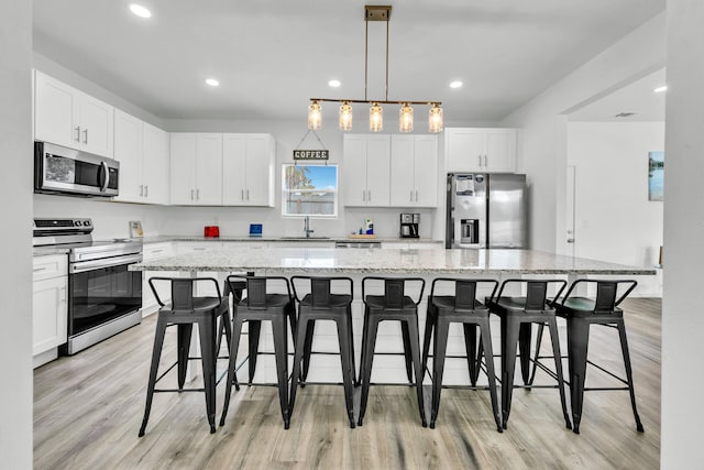 26 Daytona St, Miramar Beach, FL 32550 - kitchen with stainless steel appliances, white cabinetry, a sink, and light wood-style flooring