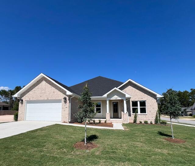 149 Leap Year Ln, Freeport, FL 32439 - view of front facade with concrete driveway, a garage, a front lawn, and brick siding