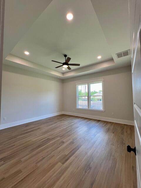 149 Leap Year Ln, Freeport, FL 32439 - unfurnished room with baseboards, wood finished floors, and a raised ceiling