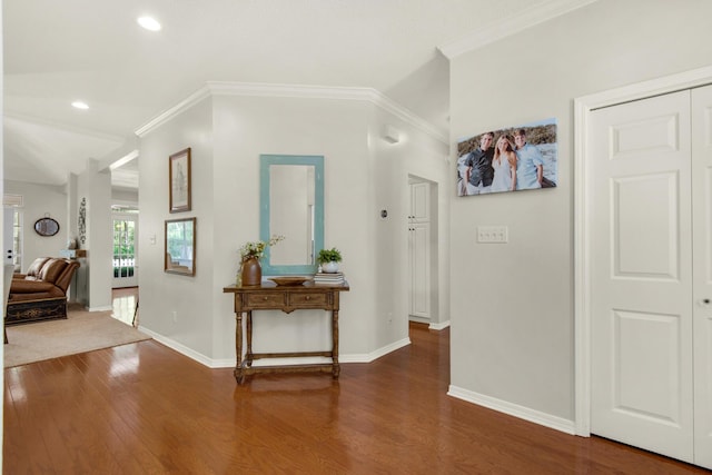 hall with crown molding, baseboards, and wood finished floors
