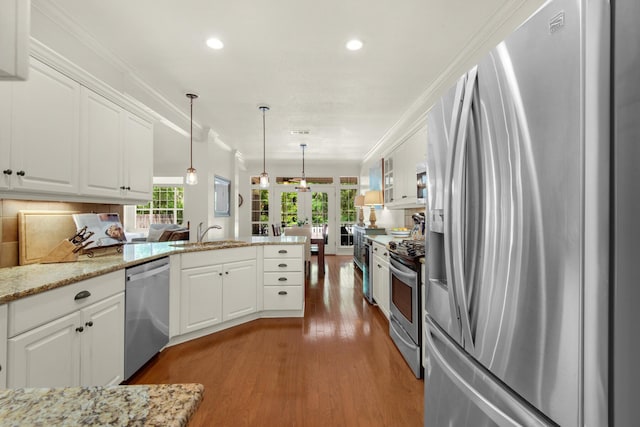 kitchen featuring appliances with stainless steel finishes, a sink, plenty of natural light, french doors, and wood finished floors