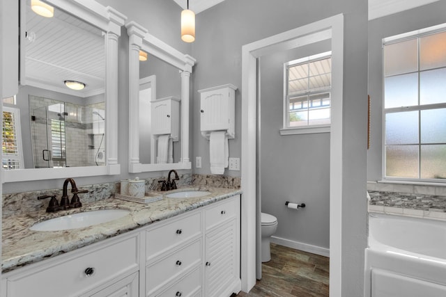 full bathroom featuring toilet, baseboards, a shower stall, and a sink