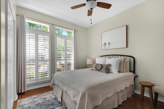 bedroom featuring a ceiling fan, baseboards, and wood finished floors