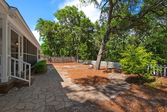 view of patio / terrace with a fenced backyard, ceiling fan, and a sunroom