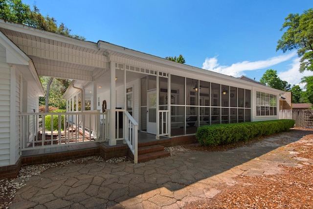 back of property with a sunroom