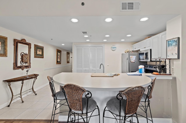 1751 Scenic Highway 98 Unit 212, Destin, FL 32541 - kitchen featuring stainless steel appliances, a breakfast bar area, baseboards, light countertops, and white cabinetry
