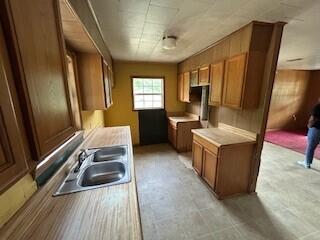 kitchen featuring a sink, brown cabinets, and light countertops