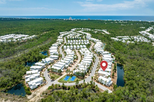 aerial view of residential area with a heavily wooded area and a nearby body of water