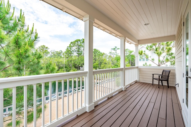 wooden deck with view of wooded area