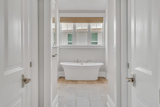 full bath featuring baseboards and a soaking tub