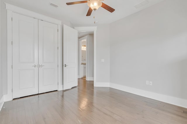 unfurnished bedroom with light wood-type flooring, baseboards, a closet, and ceiling fan
