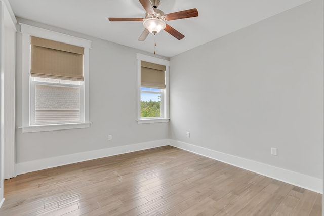 spare room featuring ceiling fan, baseboards, and light wood finished floors