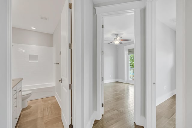 hall with light wood-type flooring and baseboards
