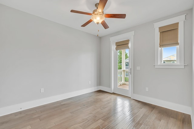 empty room featuring light wood finished floors, ceiling fan, and baseboards