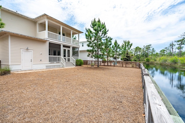 view of yard with a balcony and a water view