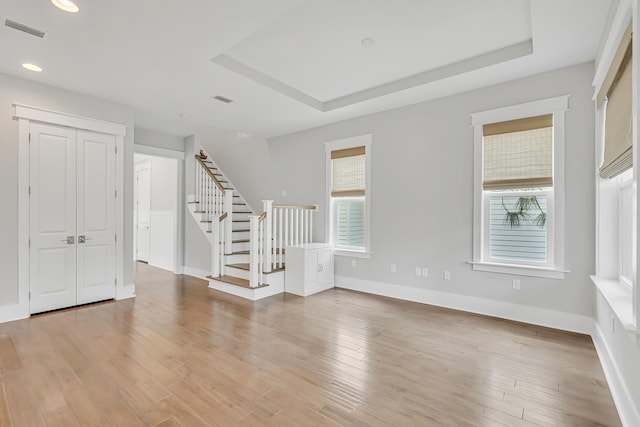 unfurnished room featuring stairs, recessed lighting, baseboards, and light wood-style floors