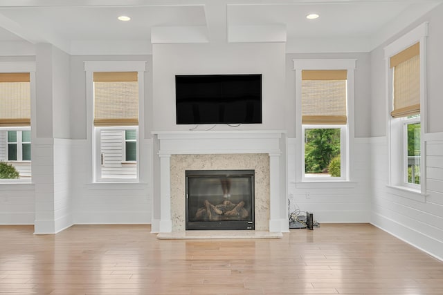 unfurnished living room featuring wainscoting, wood finished floors, a fireplace, and recessed lighting