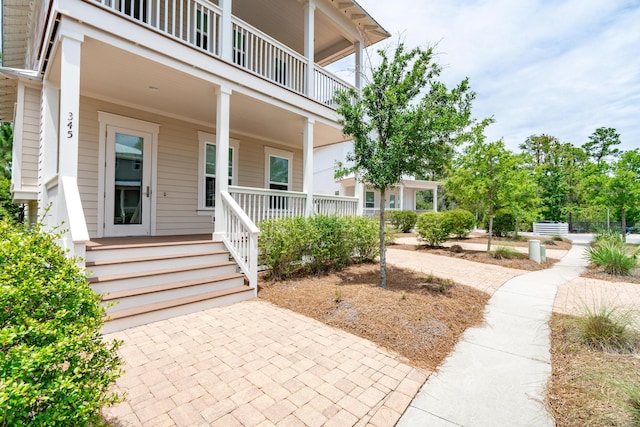 entrance to property with a porch and a balcony