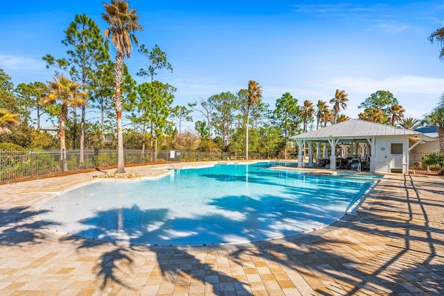 community pool with fence and a patio area