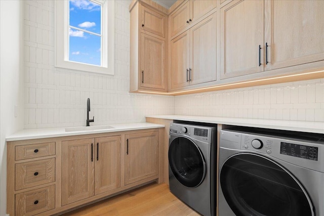 160 Heritage Dunes Ln S, Santa Rosa Beach, FL 32459 - laundry area with light wood-type flooring, washer and dryer, cabinet space, and a sink