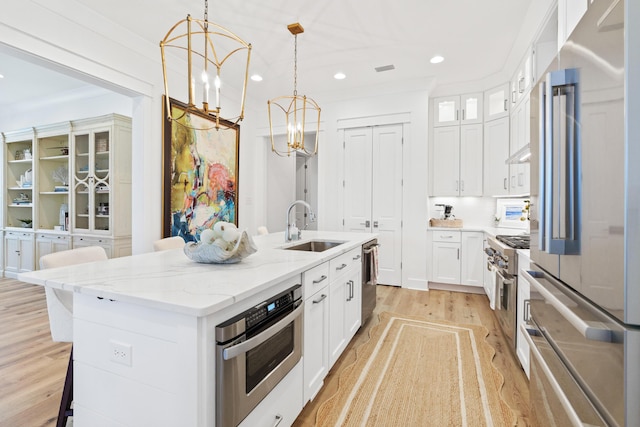 90 Basal St, Inlet Beach, FL 32461 - kitchen with stainless steel appliances, a sink, a chandelier, light wood finished floors, and a center island with sink