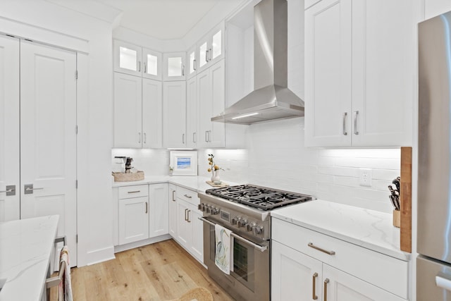 90 Basal St, Inlet Beach, FL 32461 - kitchen featuring appliances with stainless steel finishes, wall chimney exhaust hood, light wood-style flooring, and white cabinets